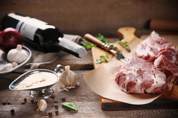 Marbled beef steak with bottle of wine and spices on wooden background