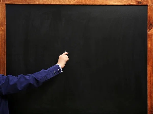 Hand writing at the clean blackboard