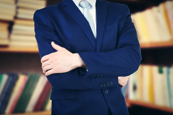 Man in suit on bookshelves background