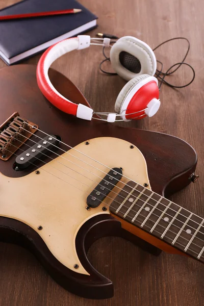 Electric guitar with headphones and notebook