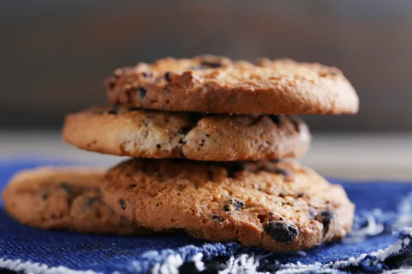 Cookies with chocolate crumbs on wooden table against blurred background, close up