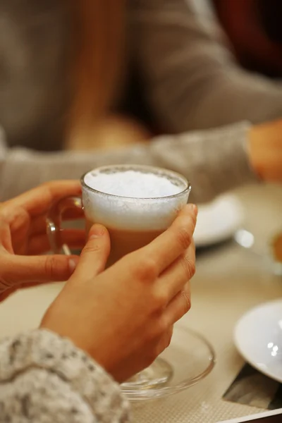 Women meeting in cafe and drinking latte