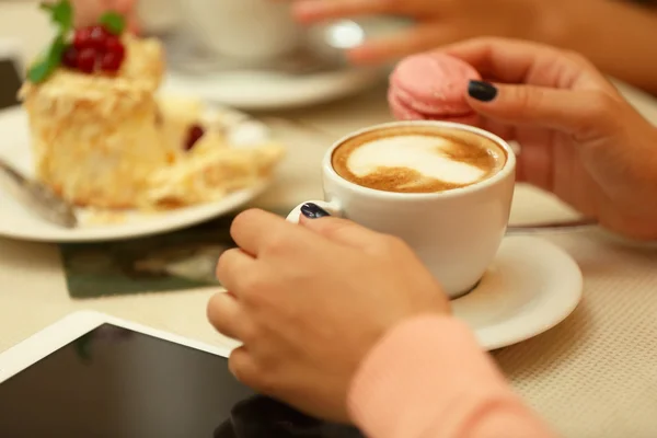 Women meeting in cafe and drinking latte