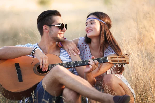 Attractive couple playing guitar