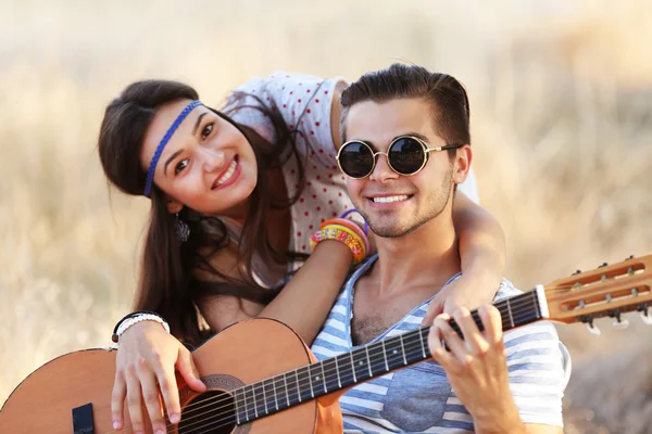 Attractive couple playing guitar