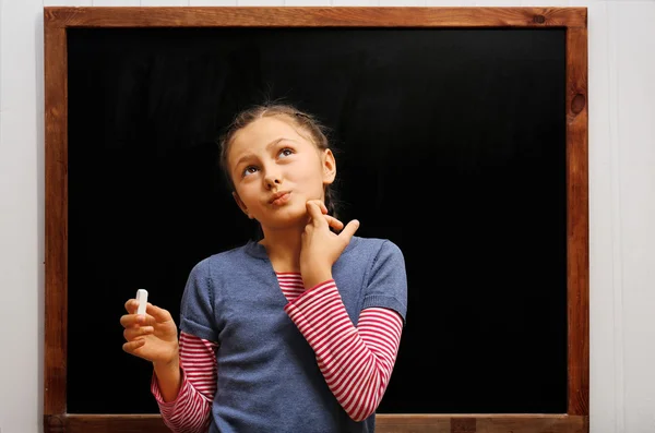 Girl posing at clean blackboard