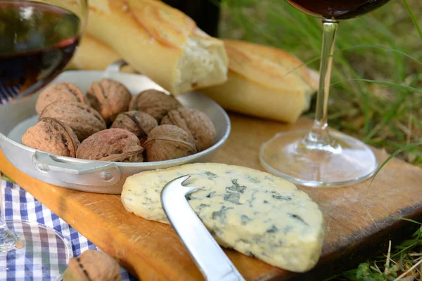 Wine, delicious cheese, walnuts and baguette