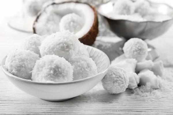 Homemade Candies in coconut flakes and fresh coconut on light background