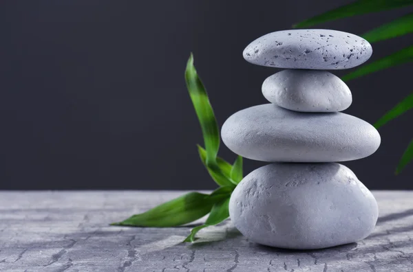 Spa stones and green flower, on dark grey background