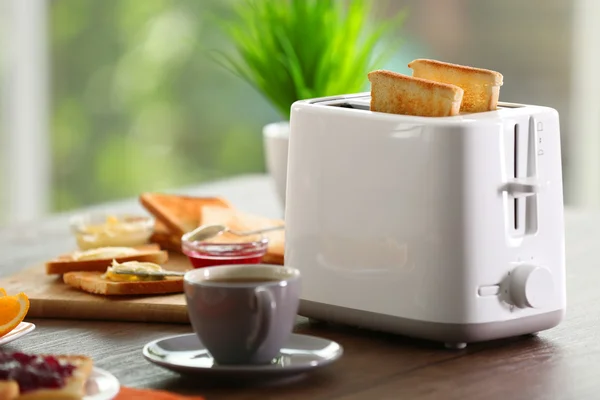 Served table for breakfast with toast, coffee and fruit, on blurred background