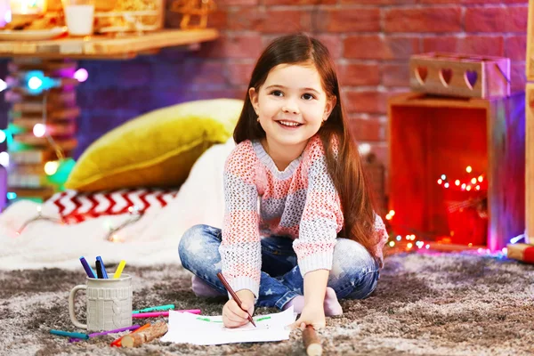 Pretty little girl painting  in Christmas decorated room