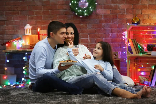 Happy family with milk and cookies in the decorated Christmas room
