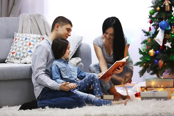 Happy family read book in the decorated Christmas room