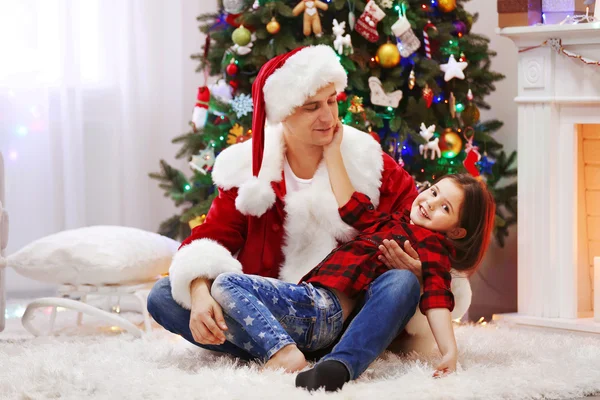 Happy father and daughter have fun in the decorated Christmas room