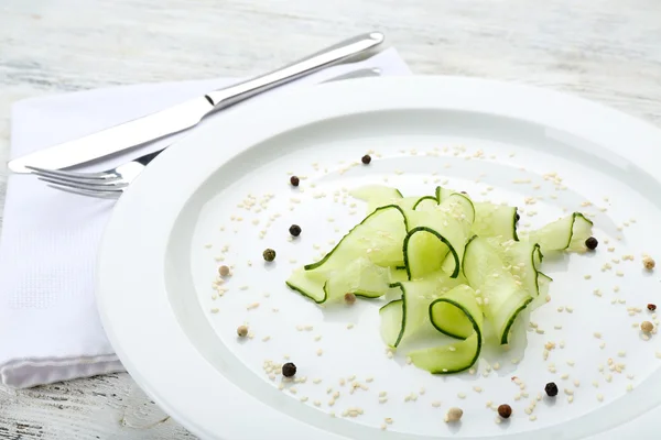 Sliced cucumbers dish on white plate in the restaurant, close up