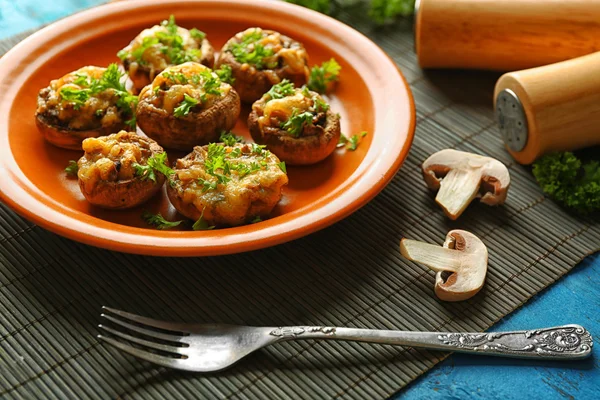 Stuffed mushrooms on plate, on table background