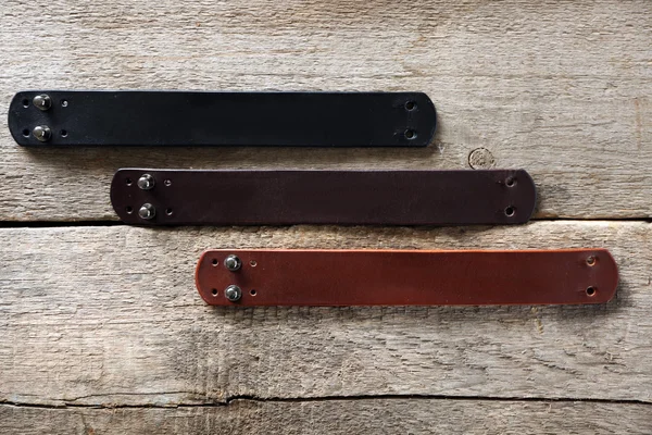 Leather bracelets on wooden background