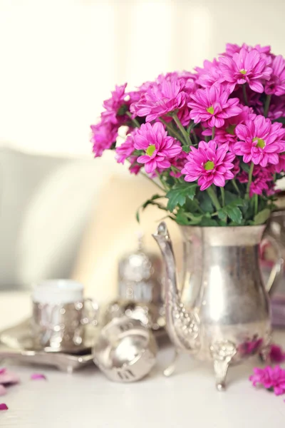 Beautiful flowers in vase on table in room