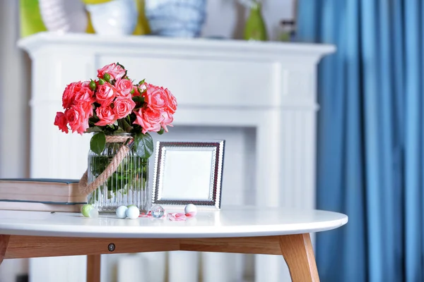 Beautiful rose in vase on table in room