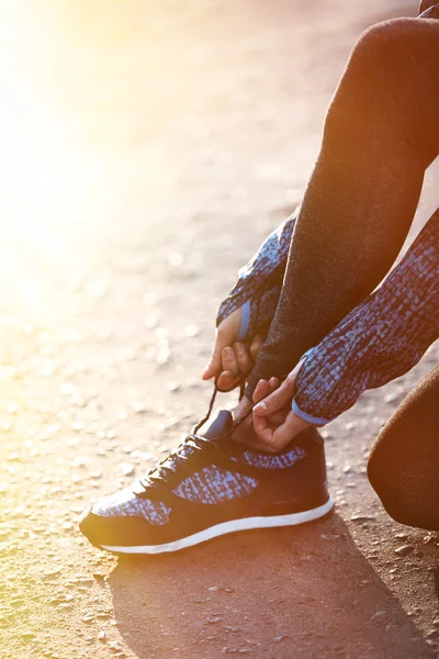 Woman in sportswear tying shoelaces