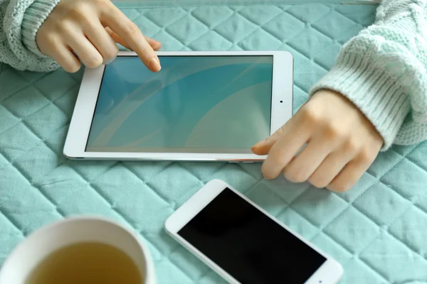 Woman using digital tablet on table close-up