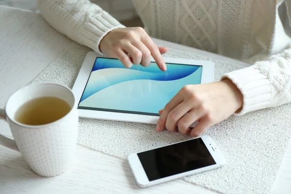 Woman using digital tablet on table close up