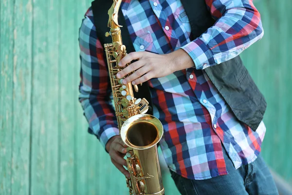 Young man playing on saxophone