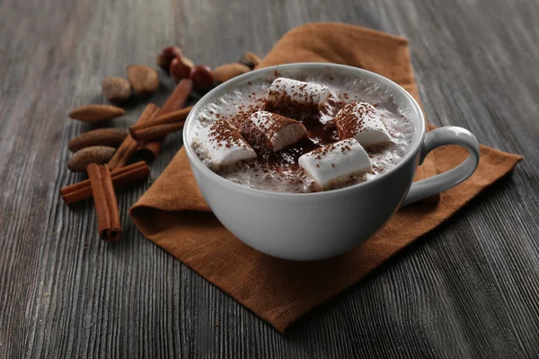 Cup of hot cacao with marshmallow, cinnamon and nuts