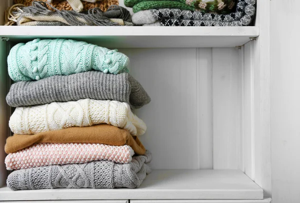 Knitting clothes on wooden shelf