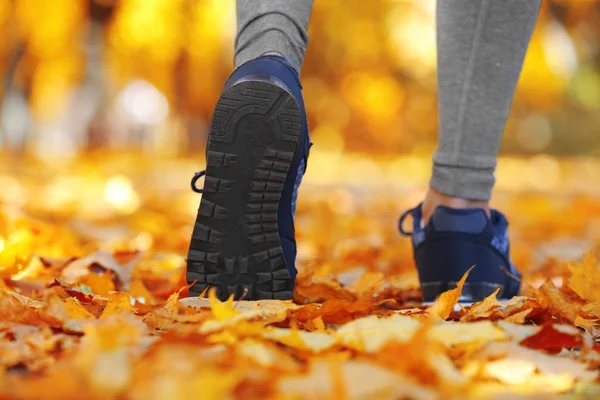 Running feet in autumn park