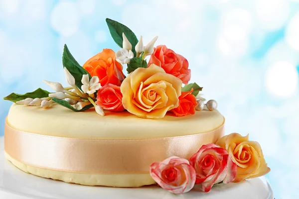 Cake with sugar paste flowers, on light background