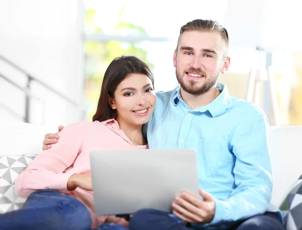 Happy couple and working on a laptop