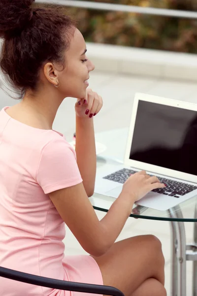 Business woman in pink dress with laptop