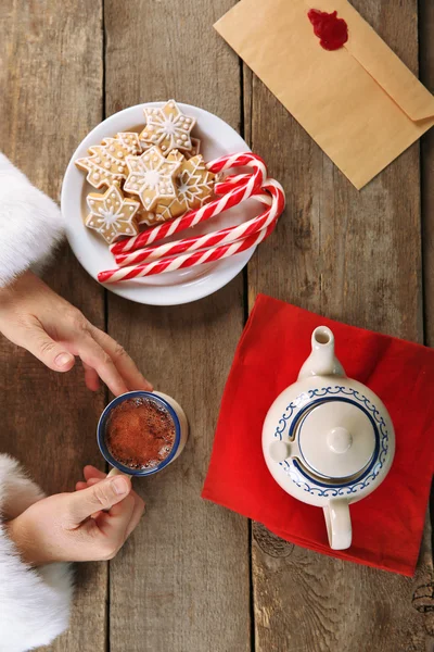 Christmas concept. Santa have a meal. Tasty cookies and cup of coffee on wooden background, close up