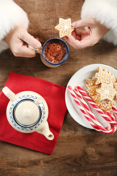 Christmas concept. Santa have a meal. Tasty cookies and cup of coffee on wooden background, close up