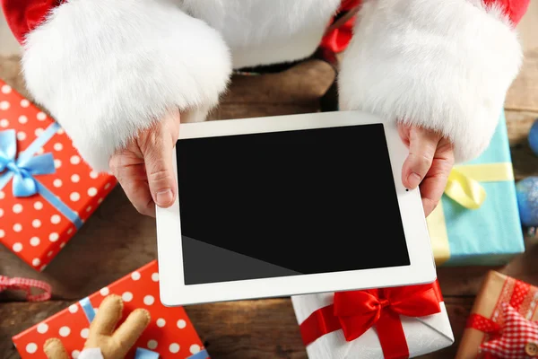 Christmas concept. Santa with tablet in hands, close up