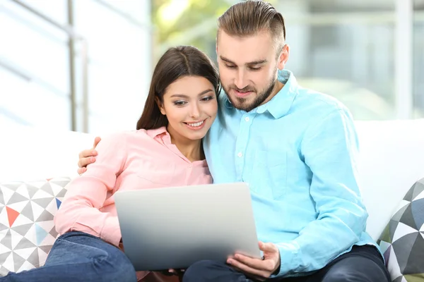 Happy couple and working on a laptop