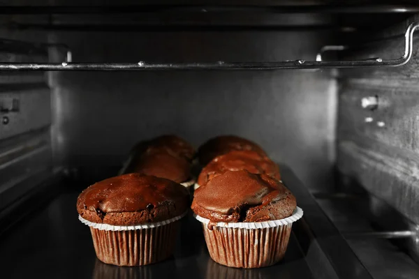 Chocolate cup-cakes in oven, close up
