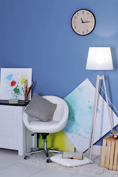 Room design with white furniture, pictures, clock and floor lamp over blue wall