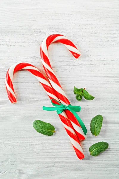 Lollipop candies with mint and stripe on light background
