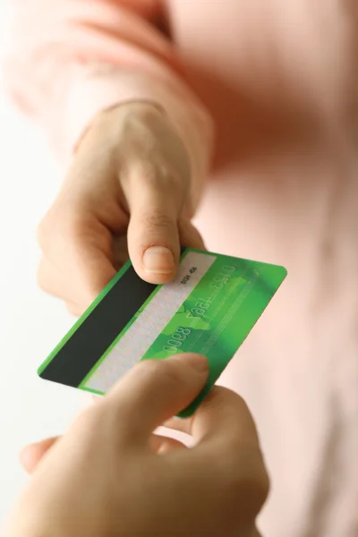 Hands holding green credit card