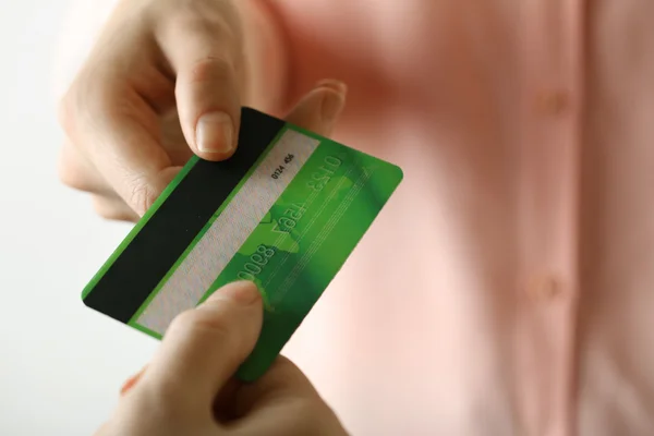 Hands holding green credit card