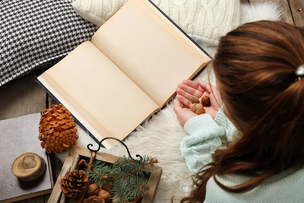 Woman holding nuts near book