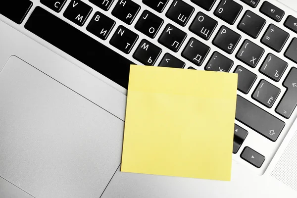 Empty yellow adhesive paper on laptop