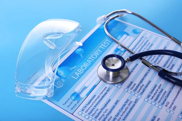 Laboratory test list, stethoscope and eyeglasses