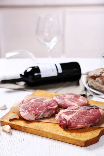Marbled beef steak with bottle of wine and spices on wooden background