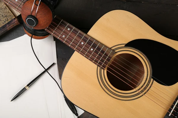 Acoustic guitar, headphones, musical notes