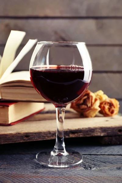 Beautiful composition with glass of wine with old books on table close up