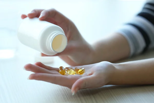 Woman spills yellow medical capsules