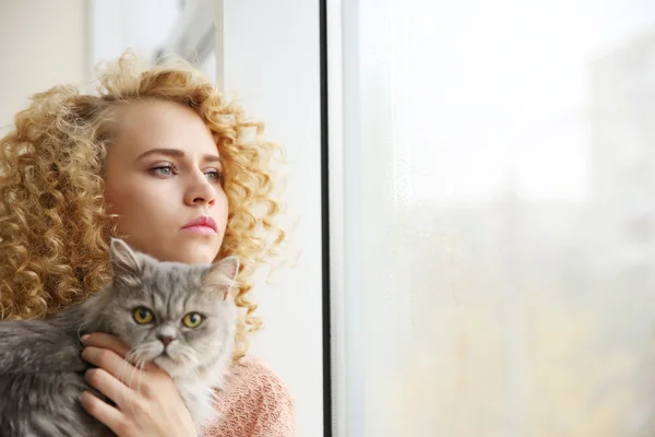 Young woman and cat on windowsill